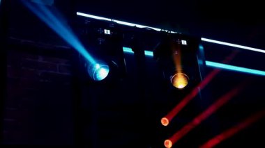 Parlak sahne ışıkları bulanık, ziyafette ışık gösterisi, konser. Kutlamalar ve ziyafetler için ışıklandırma ekipmanları. Konser sahnesi, mavi pembe spot ışıkları yerde kuru buzla parlıyor.