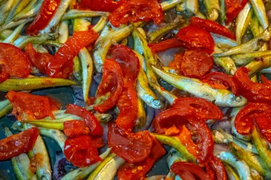 Kiraz domatesli balık pişirmek ve fırında parşömen üzerinde otlar.