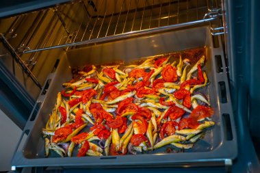 Kiraz domatesli balık pişirmek ve fırında parşömen üzerinde otlar.