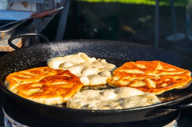 Pies are fried in oil in a frying pan. Close-up