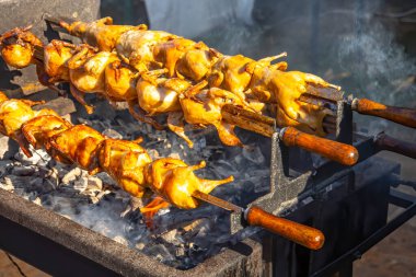 Grilling delicious poultry quails in a restaurant on grill
