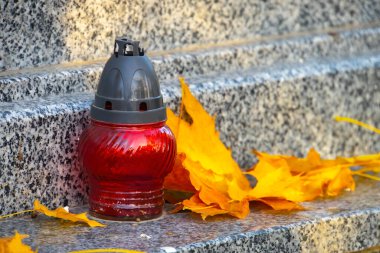 Sonbaharda yapraklı bir mezar ışığı, eski mezarlıkta klasik lambalar.