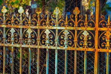 Paslı, süslü, işlenmiş demir bir çit. Madalyalı demir elementlerden yapılmış eski bir demir çitin ayrıntıları.