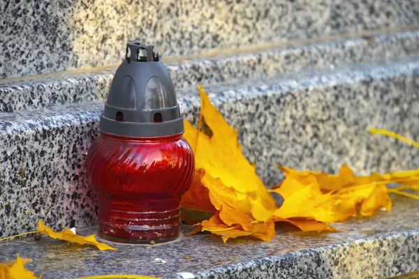 Sonbaharda yapraklı bir mezar ışığı, eski mezarlıkta klasik lambalar.