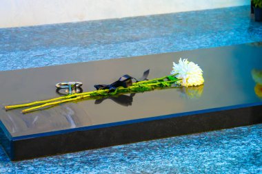 Bir mezardaki çiçekler, çiçeklerde sergilenen çiçekler mezarlıktaki mezar taşında duruyor.