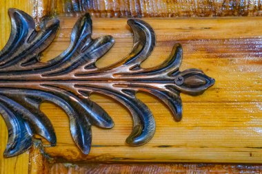 Ahşap kapıdaki metal yaprak dekoru