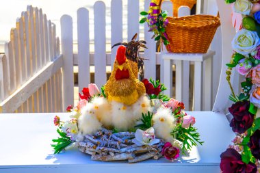 Küçük yuvada dekoratif tavuklar ve yumurtalarla Paskalya kompozisyonu 