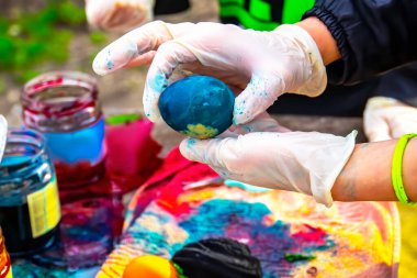 Paskalya Ailesi gelenekleri. Annem Paskalya tatili için yumurtaları boyayla süslerken mutfak masasında birlikte oturur, seçici bir şekilde.