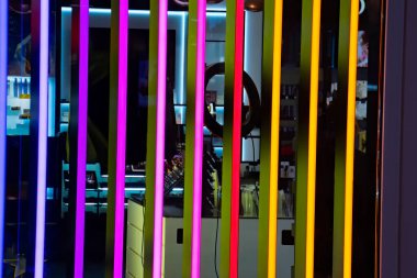 Odada çok renkli neon ışıklar var. Siyah duvarda renkli floresan lamba