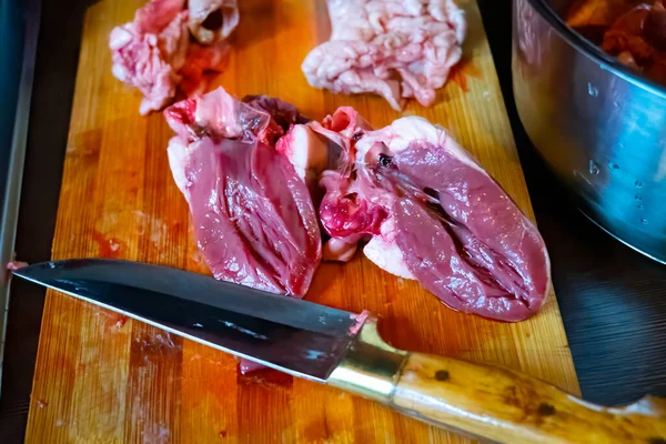 stock image Raw sheep heart on wooden board for cutting meat with knife and spices.