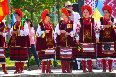 CHISINAU, MOLDOVA - 19 Mayıs 2023 'te Chisinau, Moldova' da düzenlenen Uluslararası Nakış Günü 'nde ulusal kostümlü ve başlarında çelenk olan genç kızlar.