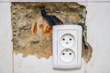 Beyaz bir duvarda eski bir elektrik prizi
