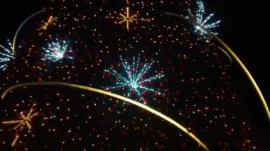 Karlı gecelerde süslemeleri ve aydınlatmaları olan büyük, güzel bir Noel Ağacı. Yılbaşı ve Noel tatili geçmişi. Şenlikli kış şehri manzarası.