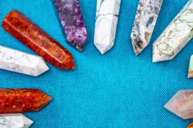 Renkli çeşitli işlenmemiş ve işlenmemiş mineral taşlar, değerli taşlar ve şifalı taş koleksiyonu kumaş zemin üzerinde Reiki çakra kristallerini iyileştiriyor. Gemstones refah, uyum, meditasyon, rahatlama için