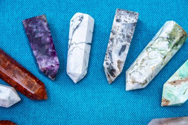Renkli çeşitli işlenmemiş ve işlenmemiş mineral taşlar, değerli taşlar ve şifalı taş koleksiyonu kumaş zemin üzerinde Reiki çakra kristallerini iyileştiriyor. Gemstones refah, uyum, meditasyon, rahatlama için