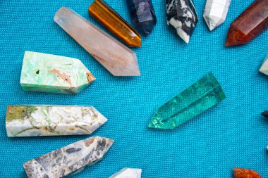 Renkli çeşitli işlenmemiş ve işlenmemiş mineral taşlar, değerli taşlar ve şifalı taş koleksiyonu kumaş zemin üzerinde Reiki çakra kristallerini iyileştiriyor. Gemstones refah, uyum, meditasyon, rahatlama için