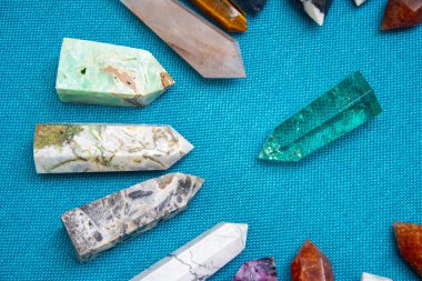 Renkli çeşitli işlenmemiş ve işlenmemiş mineral taşlar, değerli taşlar ve şifalı taş koleksiyonu kumaş zemin üzerinde Reiki çakra kristallerini iyileştiriyor. Gemstones refah, uyum, meditasyon, rahatlama için