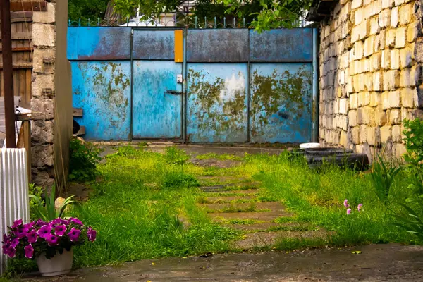 Kır evinin bahçesinde mavi demir kapı