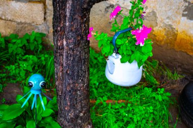 Bahçedeki çalılıklarda duran ahtapot heykelciği.