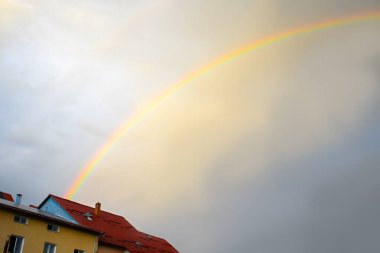 Mavi gökyüzü ve gökkuşağı ile bulutlar.