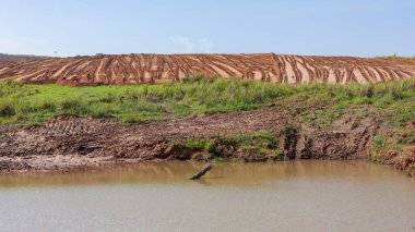 Endüstriyel inşaat ağır makineleri, önceki tarım arazilerindeki yeni emlak geliştirme planı için platoda toprak kumu hareket ettiriyor..