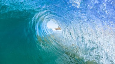Wave surfing surfer tube ride view inside out hollow crashing blue water swimming water photo