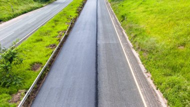 Tek şeritli yol güzergahı yeni asfalt katranla kaplı. Araç güvenliği için. Başlık Fotoğrafı.