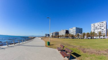 Cape Town Atlantic ocean coastline walking promenade apartments mountains blue sky lifestyle landscape.