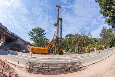 Yol şeritleri için köprü genişlemeleri. Ağır vinç makineleriyle yeni çelik koniler için endüstriyel mühendislik sondajı. Güçlü temeller için toprak deliklerine beton konulacak..
