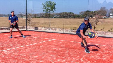Padel Tenis oyun aksiyon takımı, dışarıdaki astro yüzey camlı korttaki oyuncuları iki katına çıkardı.