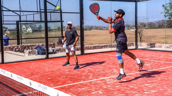 stock image Padel Tennis game action team doubles players on outdoor astro surface  glass walled court.