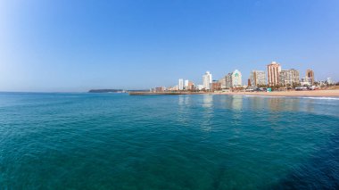 Durban sahili berrak mavi deniz suları sahil şeridi boyunca iskele iskeleleri, oteller apartmanlar manzaralı bir tropikal hava manzarası.