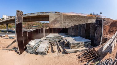 Industrial Road Highway Expansion of Ramp Flyover foundations panels scaffolding materials at earthwork site  on going project landscape close-up photograph. clipart