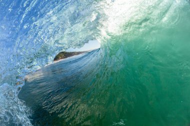 Okyanus dalgası içi boş tüp suya çarpıyor dudak geri yakıyor güneş ışığını yakıyor. Yüzücülerin yakın çekimi, sörfçülerin kıyı manzarası..