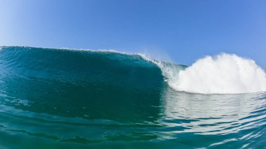 Ocean wave swimming front confrontation of large wall of blue water power crashing. clipart