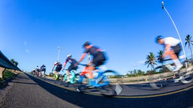 Bisiklet sürücüleri yakın çekim sabah mavi gökyüzü hareket hızı bulanıklığı kıyı karayolunda tanınmayan bisikletçiler.
