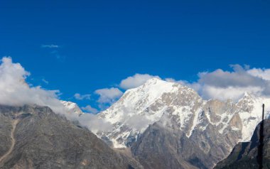 Hindistan 'ın uzak Himalaya bölgesinde engebeli dağları, dolambaçlı yolları ve berrak mavi gökyüzü ile Spiti Vadisi' nin nefes kesici manzaraları..