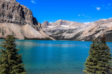 Turkuaz suları ve dağ zeminiyle Banff Ulusal Parkı 'ndaki buzul tarlaları boyunca uzanan güzel Bow Gölü..