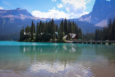 Yoho Ulusal Parkı 'ndaki huzurlu Zümrüt Gölü turkuaz suları, dağ yansımaları ve gür dağlık ormanlarıyla.
