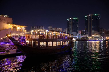 Dubai 'nin ışıltılı gökdelenleri, kuleleri, suları, tekneleri ve Orta Doğu' daki canlı şehir yaşamlarıyla parıldayan gece silueti..