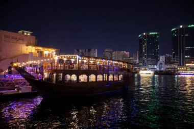 Dubai 'nin ışıltılı gökdelenleri, kuleleri, suları, tekneleri ve Orta Doğu' daki canlı şehir yaşamlarıyla parıldayan gece silueti..