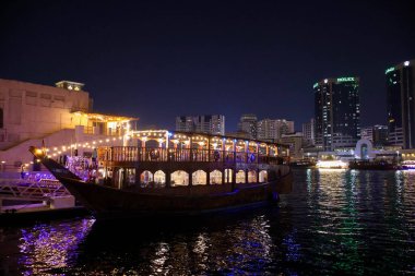 Dubai 'nin ışıltılı gökdelenleri, kuleleri, suları, tekneleri ve Orta Doğu' daki canlı şehir yaşamlarıyla parıldayan gece silueti..