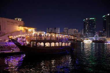 Dubai 'nin ışıltılı gökdelenleri, kuleleri, suları, tekneleri ve Orta Doğu' daki canlı şehir yaşamlarıyla parıldayan gece silueti..