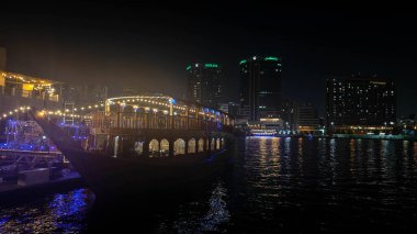 Dubai 'nin ışıltılı gökdelenleri, kuleleri, suları, tekneleri ve Orta Doğu' daki canlı şehir yaşamlarıyla parıldayan gece silueti..