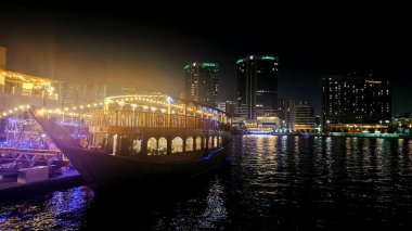 Dubai 'nin ışıltılı gökdelenleri, kuleleri, suları, tekneleri ve Orta Doğu' daki canlı şehir yaşamlarıyla parıldayan gece silueti..