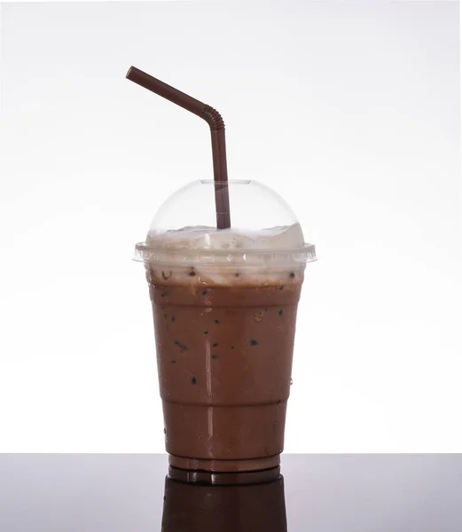 stock image Delicious iced cocoa in takeaway glass, topped with milk foam, on white background and black glass floor.