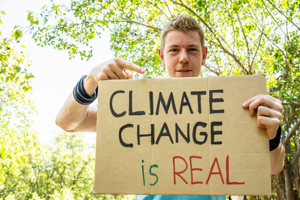 Protester holding sign Stop Climate Change. Man with placard at protest rally demonstration, strike against global warming.