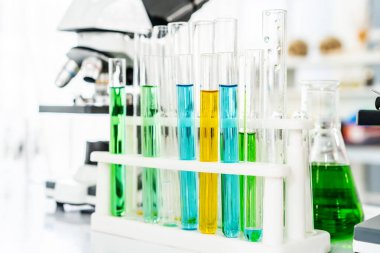 Renkli laboratuvar ya da sınıf test tüpleri ve metal mercekli mikroskop, bilim ve eğitim. Bilimsel deney, Araştırmacı, Tıp veya Bilim Laboratuvarı Konsepti,