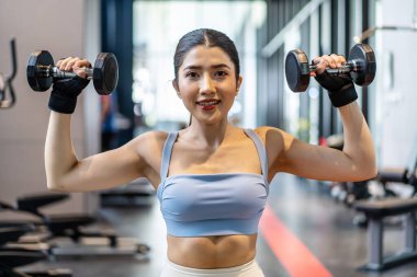 Ağırlık antrenmanı, arka planda ekipmanla ağırlık kaldıran Asyalı genç bir kadın güçlü vücut şekline sahip spor giyim kız antrenmanı, fotokopi alanı olan Asya yaşam tarzı.
