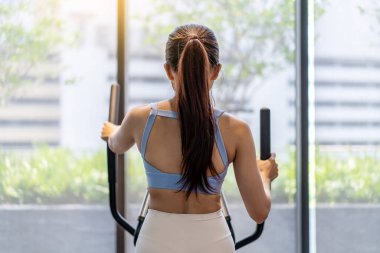 Genç Asyalı bir kız spor salonunda koşu bandında koşuyor kaslı sporcular spor salonunda aktif olarak antrenman yapıyor fitness merkezinde kadın antrenmanı yapıyor. Kardiyo egzersizi yapan, egzersiz yapan kadın kilo kaybediyor.